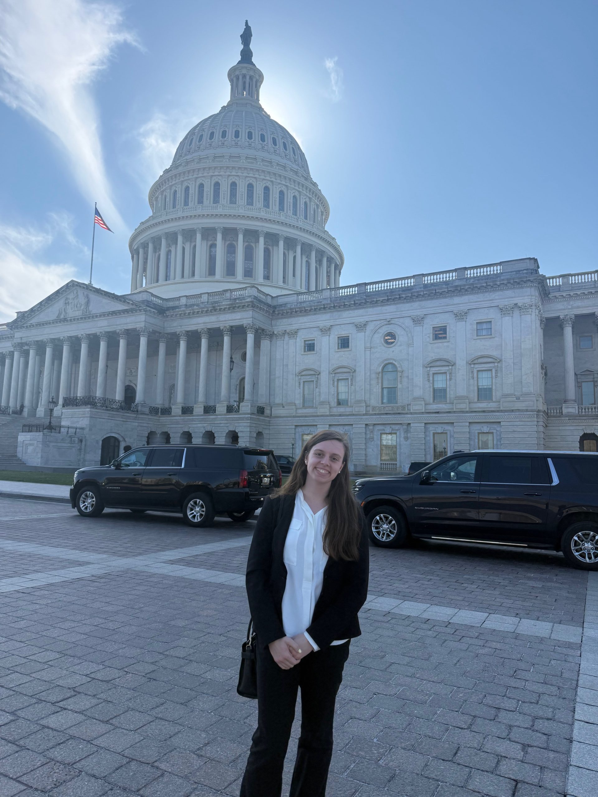 Closeup of woman standing in front of the US Capitol building